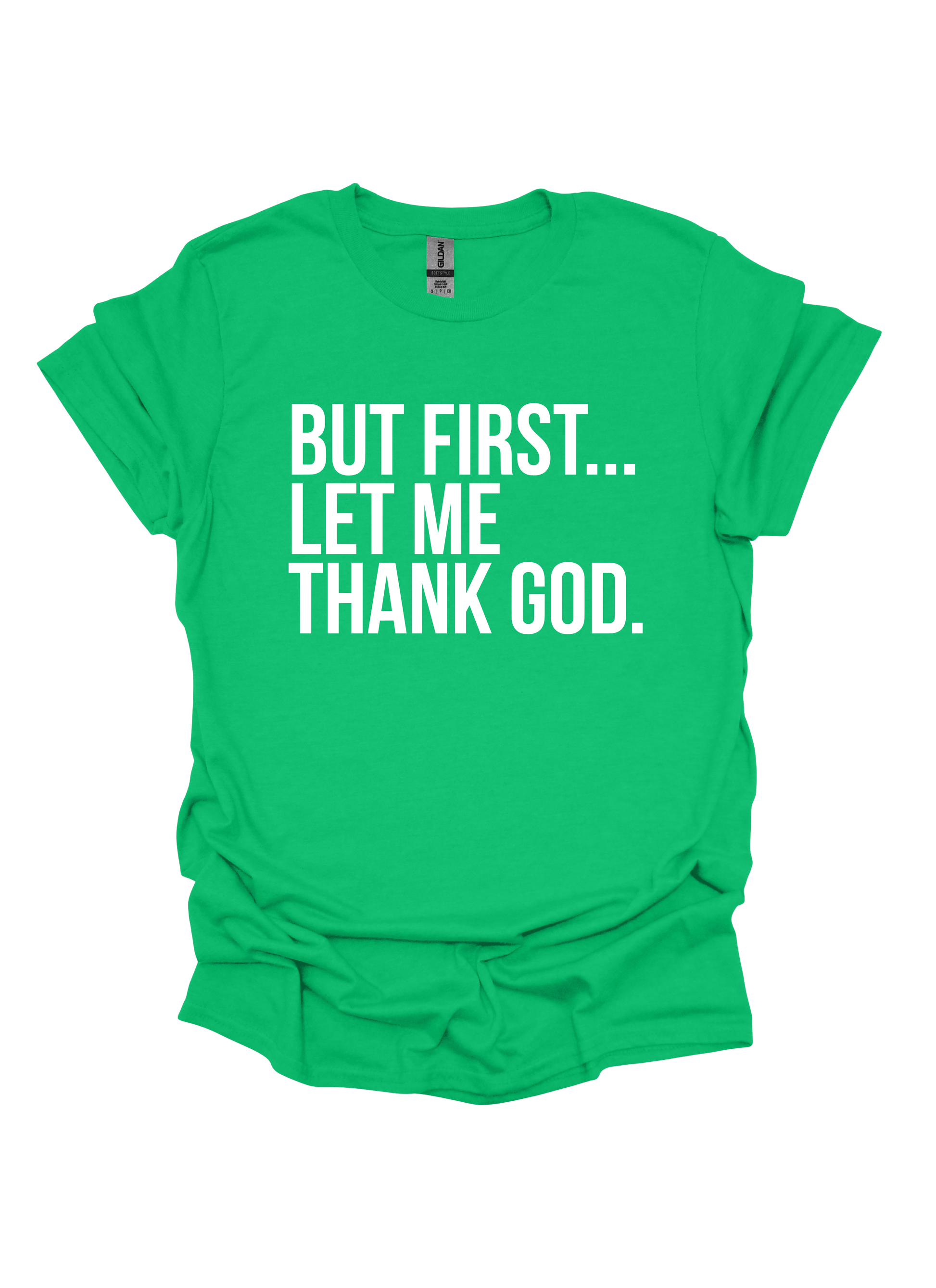 Green t-shirt with white text 'BUT FIRST... LET ME THANK GOD.' on a white background