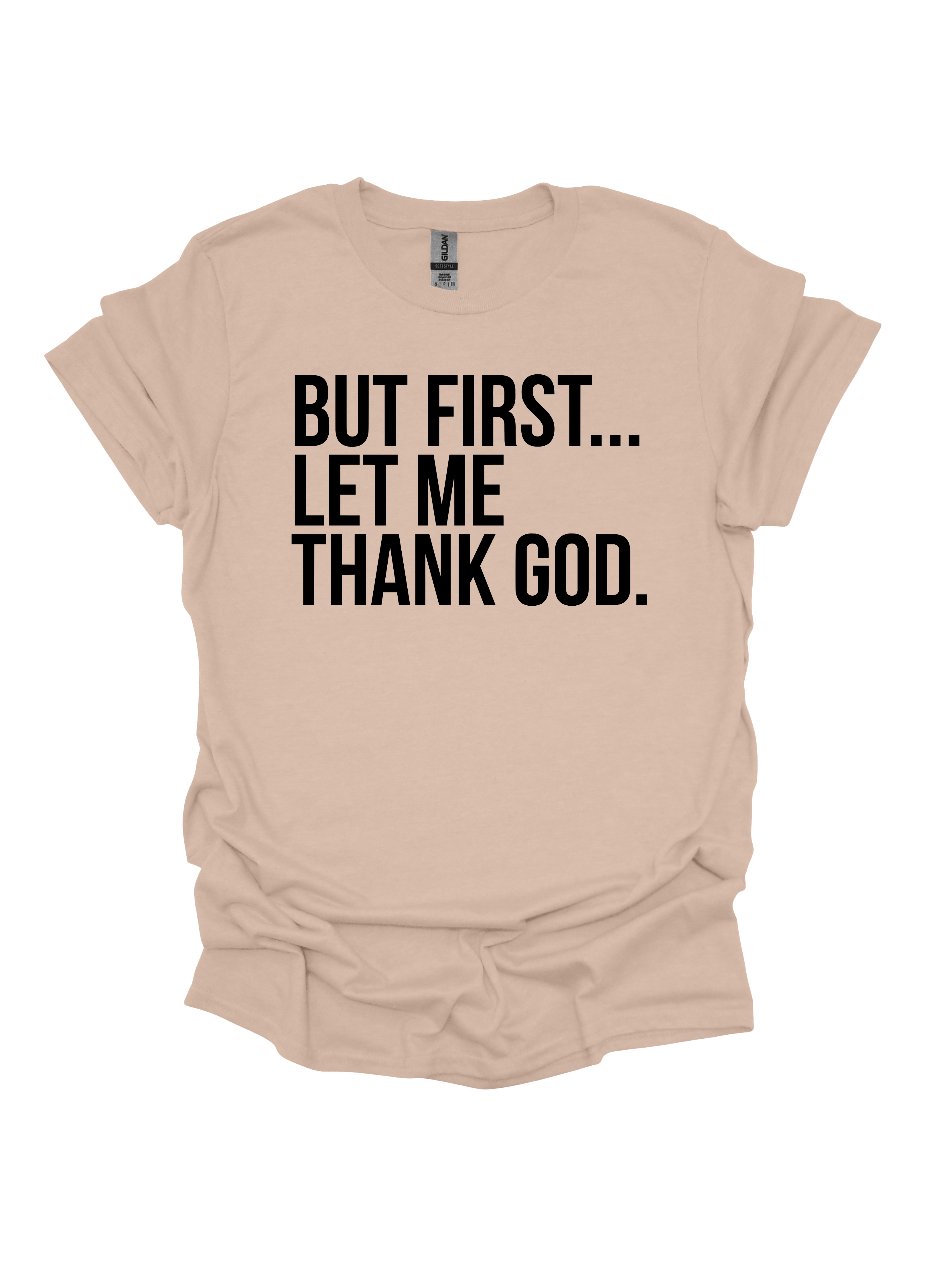 Sand t-shirt with black text 'But first... let me thank God' on a white background